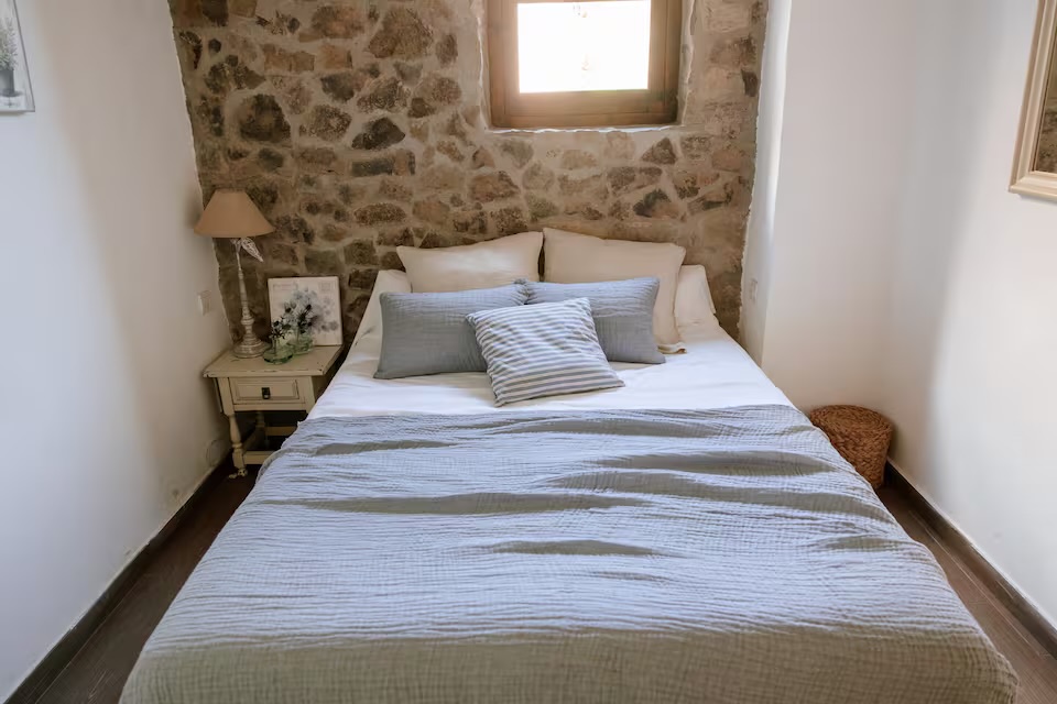Habitació 4: llit de matrimoni amb paret de pedra vista