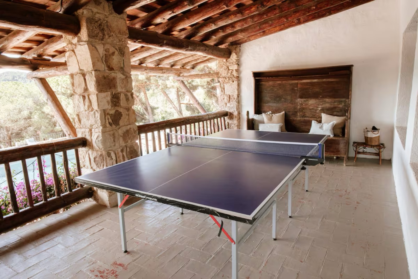Taula de ping-pong a les golfes, sota les bigues de fusta